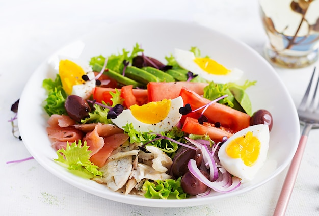 Insalata di salmone salato e dorado al forno con verdure, pomodori, uova e avocado