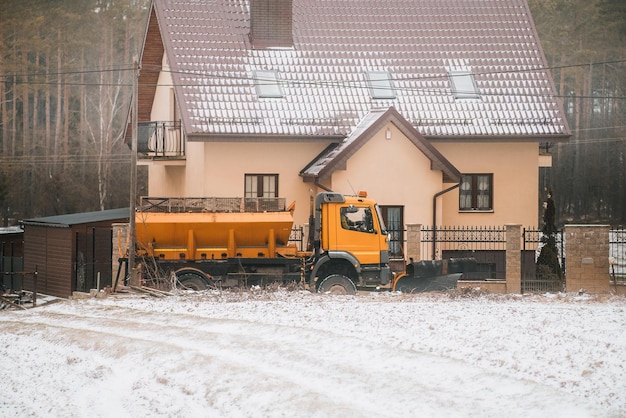 Разбрасыватель соли или соляной грузовик убирают дорогу в сельской местности после сильного снегопада.