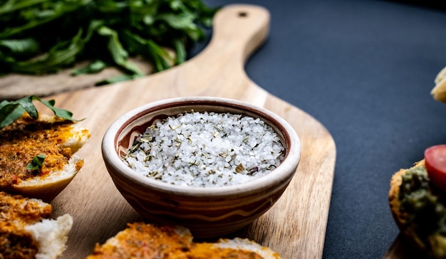 Salt with herbs and bruschettas with pesto and arugula served on wooden board traditional italian an