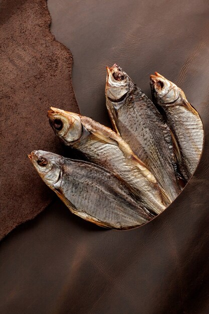 Salted airdried roach peeking out of hole in brown leather flap