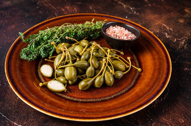 Photo salted capers in vinegar in a wooden plate