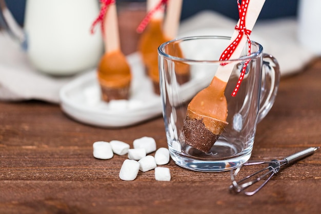 Salted caramel hot cocoa spoon in glass cup.