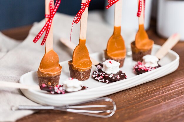 Salted caramel hot cocoa spoons on a white tray.