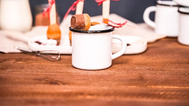 Foto cucchiai di cacao caldo al caramello salato su un vassoio bianco.
