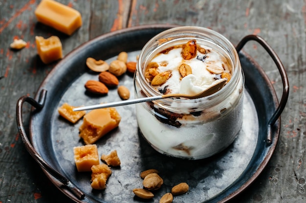 Salted caramel ice cream served in a glass jar on a blue tray italian dessert gelato