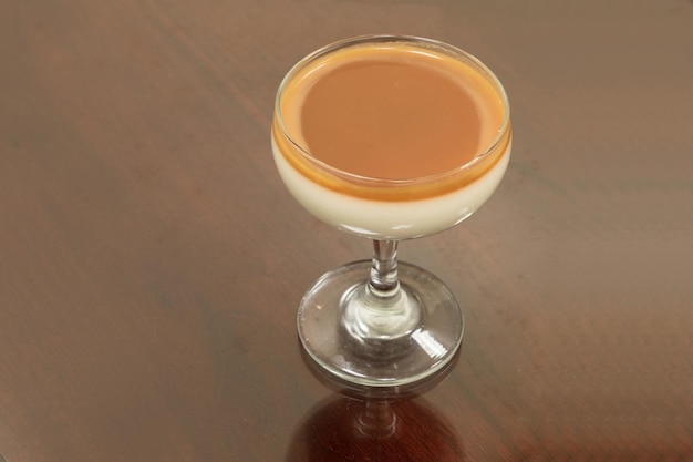 Salted caramel on top of a creamy vanilla custard in a champagne dessert glass