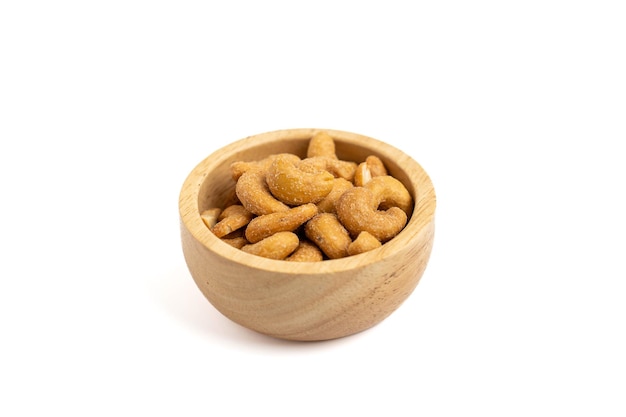 Salted cashews in a small wooden bowl on a white background Cashew nuts are nutritious foods rich in protein and good fats