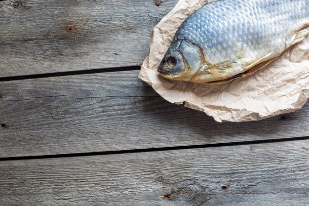 木製のしわくちゃのクラフト紙に塩干し魚のボブラ