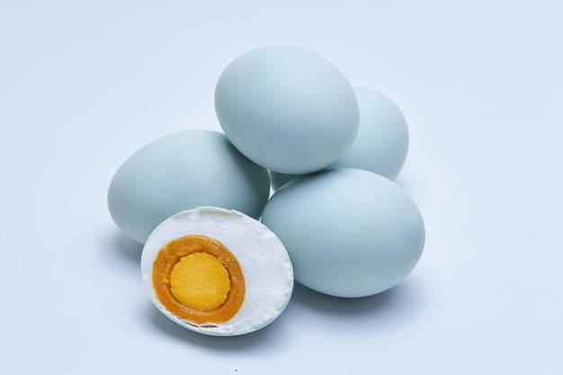 Photo salted duck eggs known as telur asin one egg cut in half exposing the inside isolated