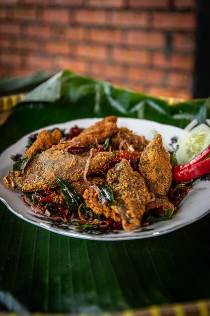 塩漬けの魚のフライ料理プレートにスパイスとハーブを添えた生の魚のシーバス