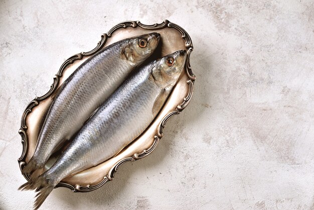 Salted herring in a nickel silver platter on a light background