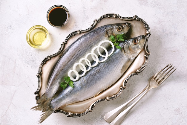 Salted herring in a nickel silver platter on a light background