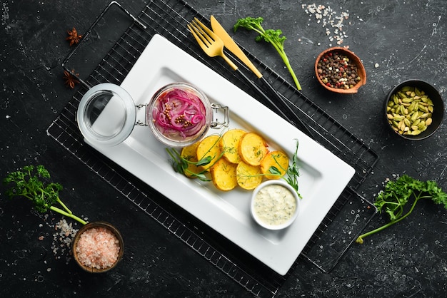 Salted herring with onions and fried potatoes Cold snacks In a white plate Top view