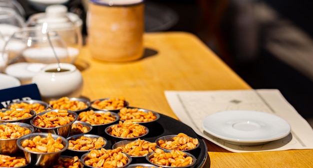 Salted peanut snack on a wooden table in a cafe on a blurred background