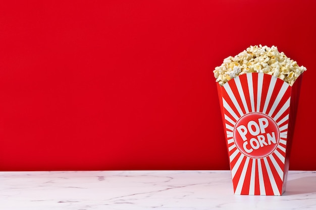 Salted popcorn on white marble and red background