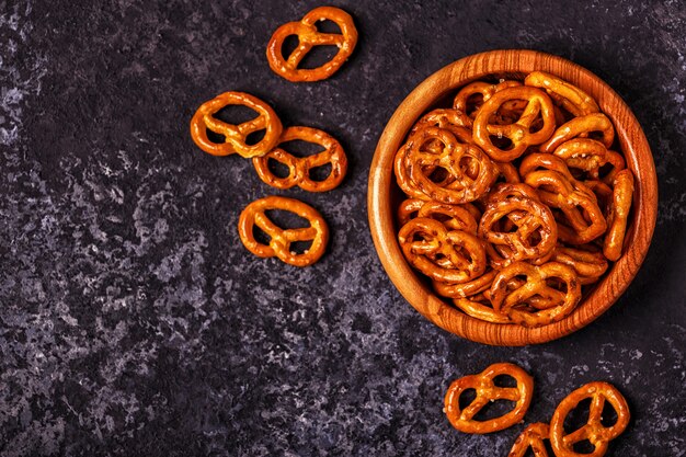 Salted pretzel in a bowl on stone background