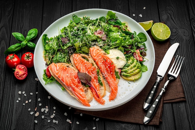 Salted salmon on croutons with fresh salad and parmesan cheese on a wooden background Healthy food concept