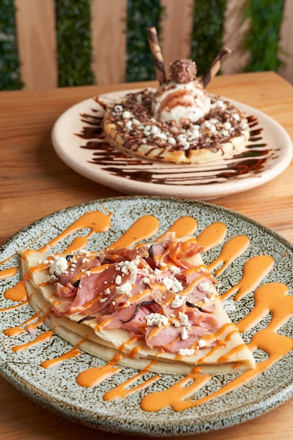 salted serrano ham crepe with chipotle dressing served with vanilla and chocolate snow waffle