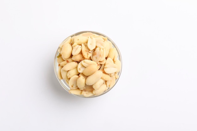 Salty peanuts in glass bowl on white background Indian snack