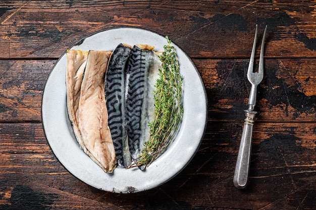 Соленая нарезанная рыба филе скумбрии в тарелке с травами Деревянный фон Вид сверху