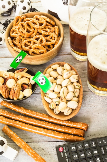 Salty snacks and beer on a table for soccer party.