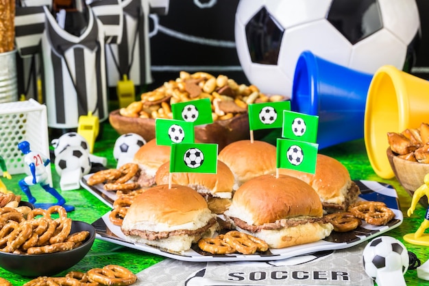 Salty snacks and beer on the table for soccer party.