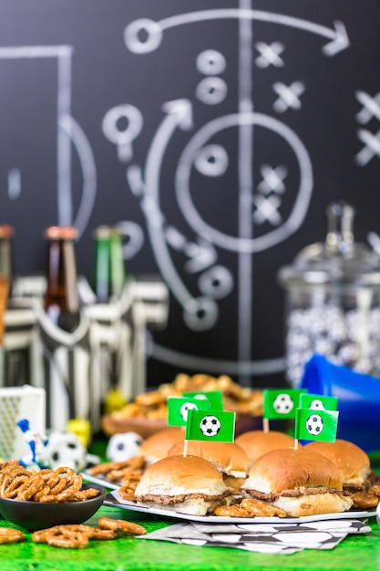 Salty snacks and beer on the table for soccer party.