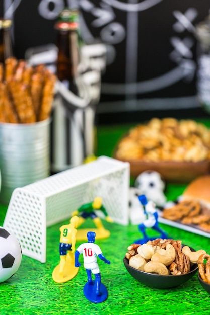 Photo salty snacks and beer on the table for soccer party.