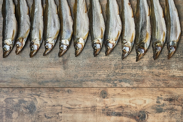 Salty stockfish on wooden table. Rainbow smelt (Osmerus mordax)