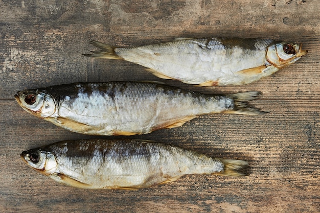 木製のテーブルの上の塩辛いstockfish。シェマヤ（Chalcalburnus）