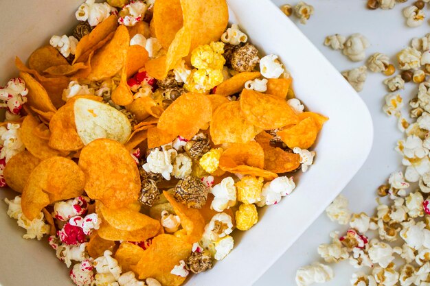 Foto popcorn salato e dolce e patatine sullo sfondo bianco a basso angolo