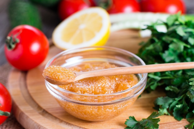 Salty yellow caviar of pike fish with spoon close up