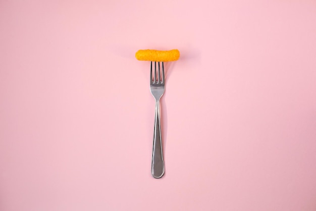 Salty yellow corn stick on a bright colored background in full screen