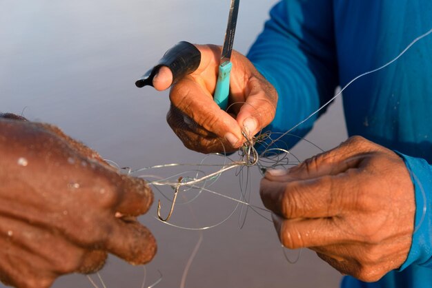 Salvador Bahia Brazil April 26 2019 Hands of fishermen untying fishing line Pole fishing