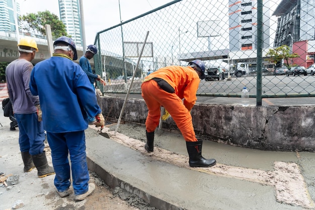 살바도르 바이아 브라질 2023년 8월 11일 살바도르 바이아의 Avenida Tancredo Neves에서 보도를 수리하는 건설 노동자들