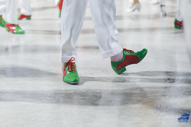 Samba dancer with white pants and red and green shoes performing in Rio de Janeiro