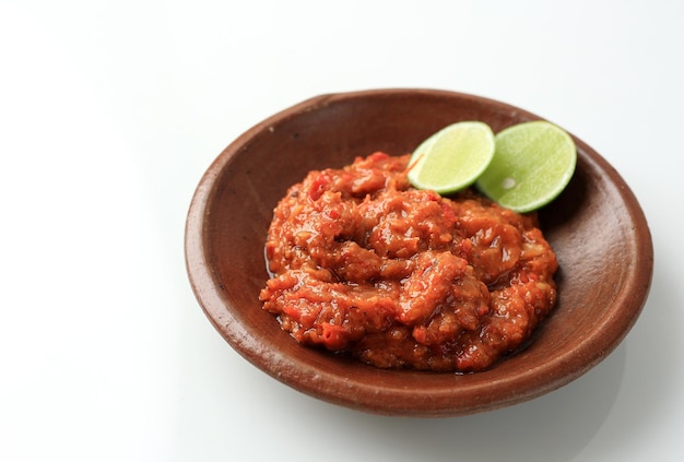 Sambal Tomat or Spicy Tomato Paste on Earthenware Plate Isolate on White