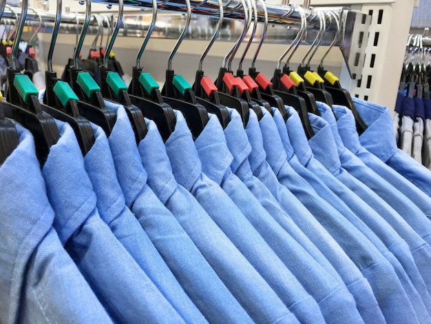 Same Styled Blue Shirts Hanging Hanging on a Rack