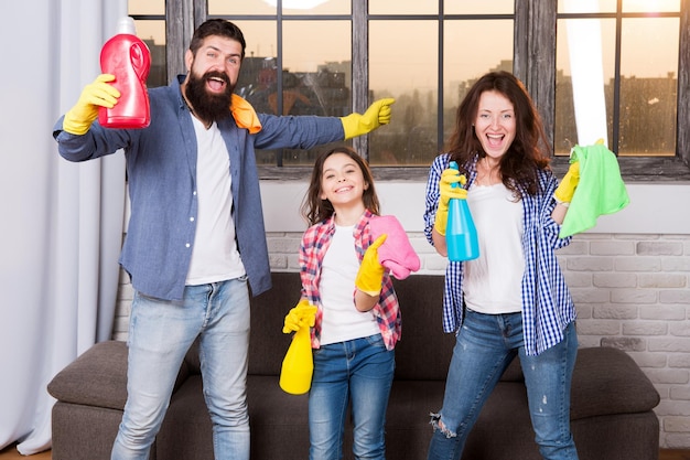 Foto samen makkelijker en leuker schoonmaken gezinszorg over netheid begin met schoonmaken schoonmaakdag familie moeder vader en dochter met schoonmaakspullen bij woonkamer wij houden van netheid en netheid