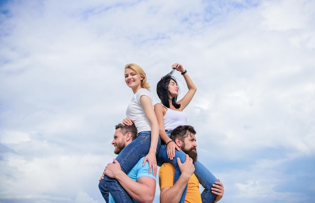 Samen plezier hebben Liefdevolle koppels die leuke activiteiten buitenshuis hebben Liefdevolle koppels genieten samen van plezier Speelse verliefde koppels lachend op de bewolkte hemel Gelukkige mannen die hun vriendinnen meeliften