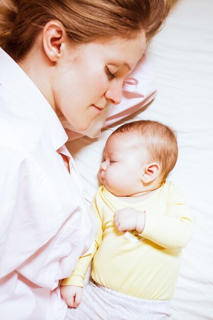 Foto samen slapende moeder en baby van drie maanden na borstvoeding op bed