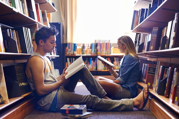 Samen studeren, maar apart Twee studenten lezen aparte studieboeken in de bibliotheek