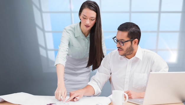 Samengesteld beeld van casual architectuurteam dat samen aan bureau werkt