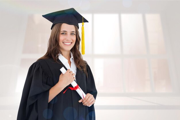 Samengesteld beeld van een glimlachende vrouw met haar diploma terwijl ze naar de camera kijkt