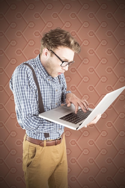 Samengesteld beeld van geeky zakenman die zijn laptop gebruikt