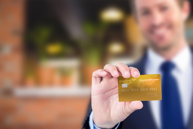 Samengesteld beeld van gelukkige zakenman die een creditcard toont