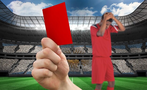 Foto samengesteld beeld van hand die rode kaart omhoog houdt aan speler tegen stadion vol voetbalfans van argentinië
