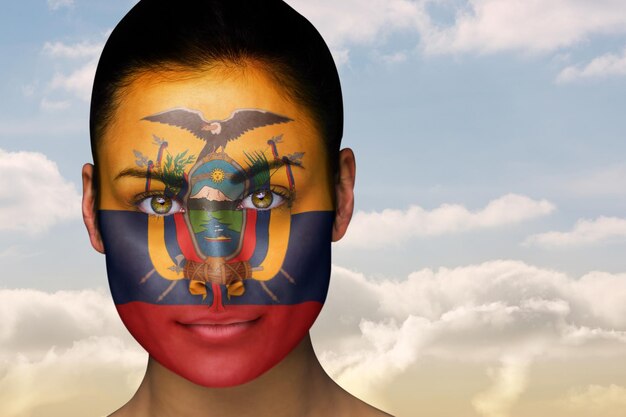 Samengesteld beeld van mooie brunette in ecuador facepaint tegen mooie blauwe hemel met wolken