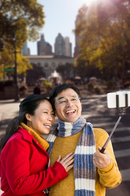 Samengesteld beeld van ouder Aziatisch echtpaar op balkon dat selfie neemt