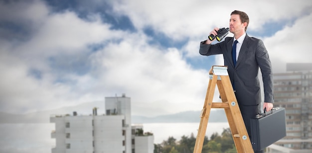 Samengesteld beeld van zakenman die op een ladder kijkt